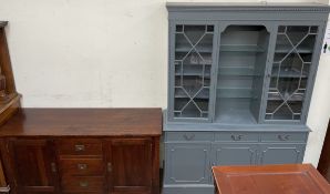 A modern oak low sideboard with three central drawers and two cupboards together with a modern wall