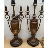 A pair of twin handled urn shaped table lamps with bronze effect decoration