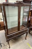 A reproduction mahogany display cabinet, with a carved cresting rail,