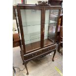 A reproduction mahogany display cabinet, with a carved cresting rail,