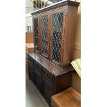 A 20th century oak dresser, the moulded cornice above three leaded glazed doors,