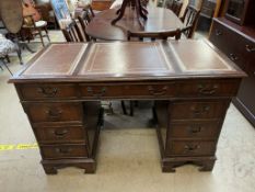 A reproduction mahogany pedestal desk with a leather inset top and two banks of drawers
