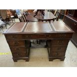 A reproduction mahogany pedestal desk with a leather inset top and two banks of drawers