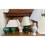 A pair of green glazed table lamps together with three other table lamps