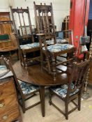 A large oak dining table of circular form (extending to an oval with an additional leaf) on square