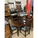 A large oak dining table of circular form (extending to an oval with an additional leaf) on square