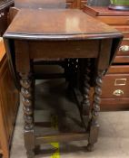 A 20th century oak gateleg dining table with an oval moulded top on barley twist legs