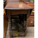 A 20th century oak gateleg dining table with an oval moulded top on barley twist legs