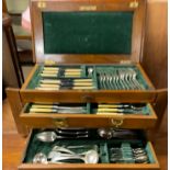 An electroplated part flatware service contained in an oak box with a hinged top and three drawers
