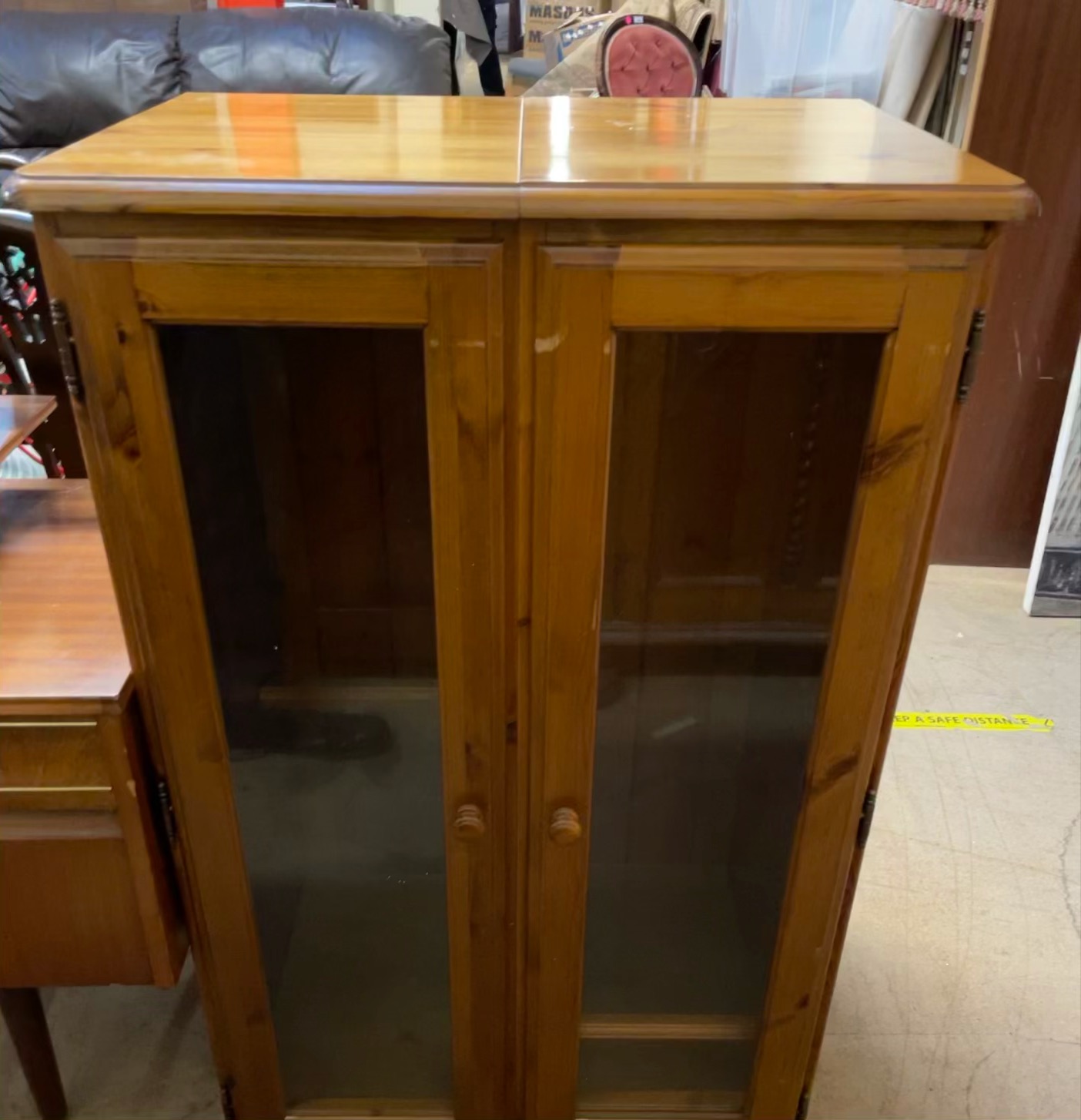 A modern pine side cabinet with a pair of glazed doors
