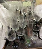 A collection of drinking glasses with black glass stems