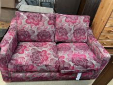 A floral decorated two seater sofa bed