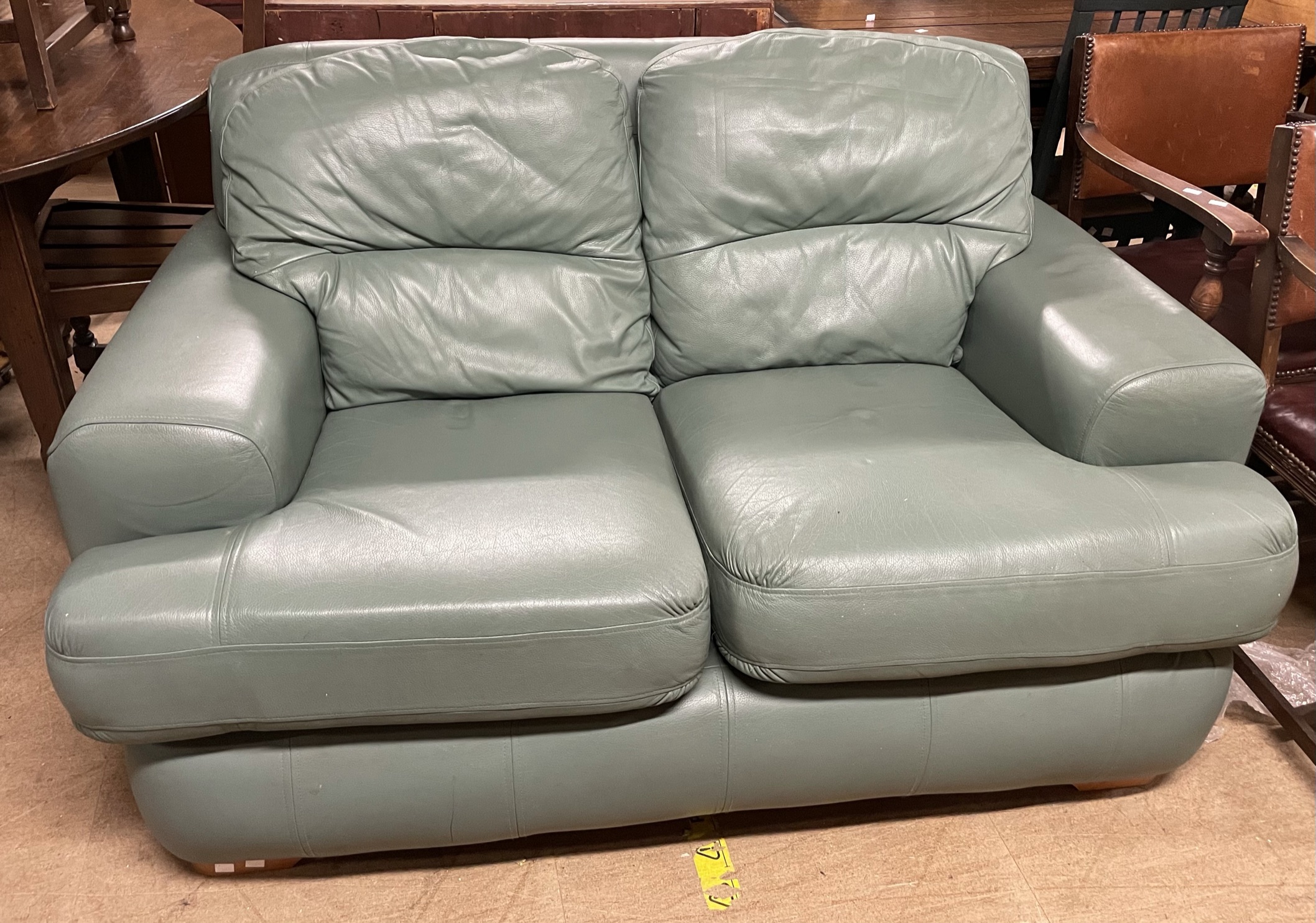 A green leather two seater settee
