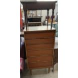 A mid 20th century teak chest with six graduated drawers on tapering legs together with a