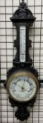 An oak framed aneroid barometer, with a leaf carved cresting, mercury thermometer,