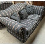 A modern two seater settee decorated with bands of flowers and leaves together with a matching