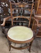 An Edwardian rosewood elbow chair with a spindle back and an oval pad seat on square tapering legs