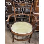 An Edwardian rosewood elbow chair with a spindle back and an oval pad seat on square tapering legs