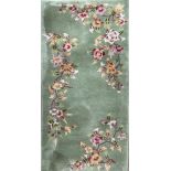 A small green ground Chinese rug decorated with flowers