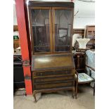 A 20th century mahogany bureau bookcase, the blind fret cornice above a pair of glazed doors,