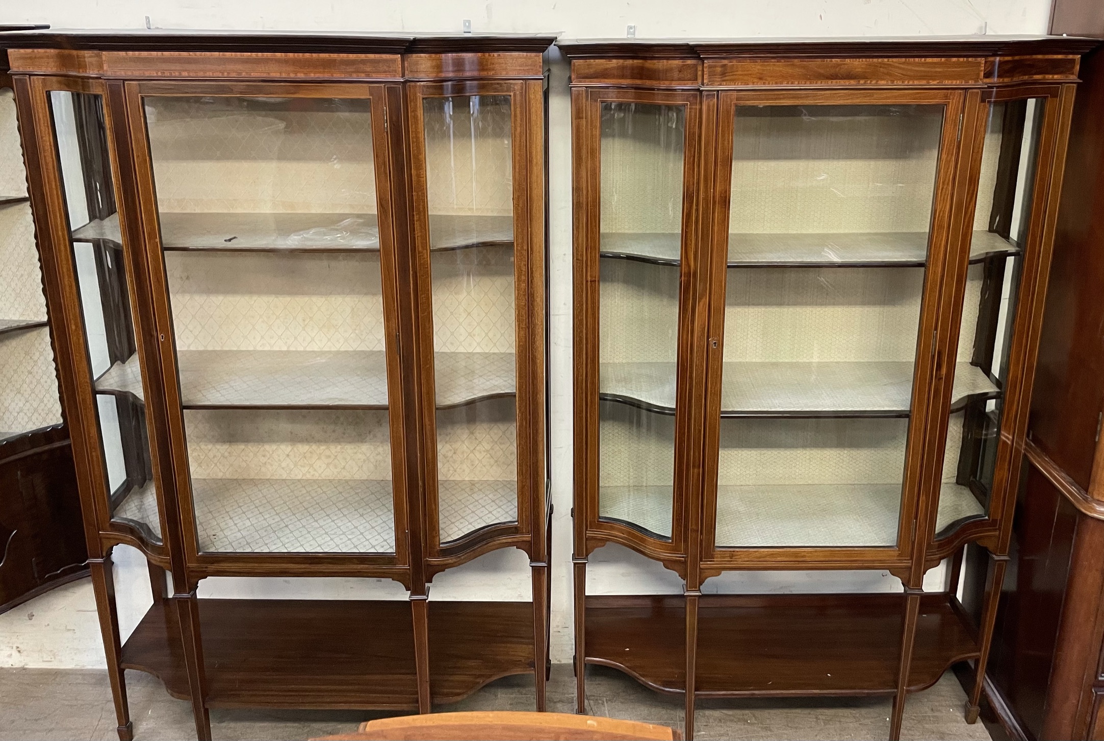 A matched pair of Edwardian mahogany display cabinets, with moulded cornice, glass doors,