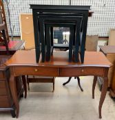 A reproduction mahogany desk with a shaped top on tapering legs together with an ebonised nest of