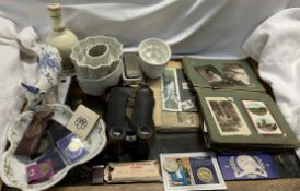 A postcard album together with coins, binoculars, jelly moulds,