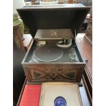 An oak cased HMV table top gramophone with a book and collection of records