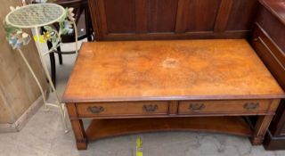 A 20th century walnut coffee table of rectangular form with two drawers and a shelf together with