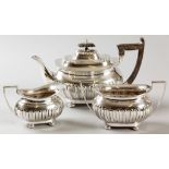 AN EDWARDIAN SILVER THREE PIECE TEASET, SHEFFIELD 1906 & 1907, WALKER & HALL, comprising a teapot,