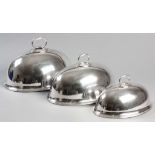 A SET OF THREE GRADUATED SILVERPLATE MEAT DOMES BY ELKINGTON & CO,. with removable C-form handles,