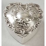 A STERLING SILVER PILL BOX BY TIFFANY & CO., the heart-shaped box with a removable cover embossed