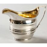 A GEORGE III SILVER CREAMER, LONDON 1801, MAKER'S MARKS INDECIPHERABLE, beaded rim, the body with