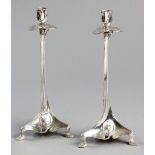 A PAIR OF ART NOUVEAU SILVERPLATE CANDLESTICKS BY JUVENTA, the flower-form candle holder on a leaf-