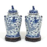 Pair of Chinese Porcelain Blue and White Dragon Temple Vase with Covers, on Carved Wood Stands, ca.