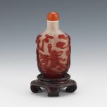 19th Century Qing Dynasty Peking Glass Snuff Bottle with Carnelian Stopper, on Carved Wood Stand