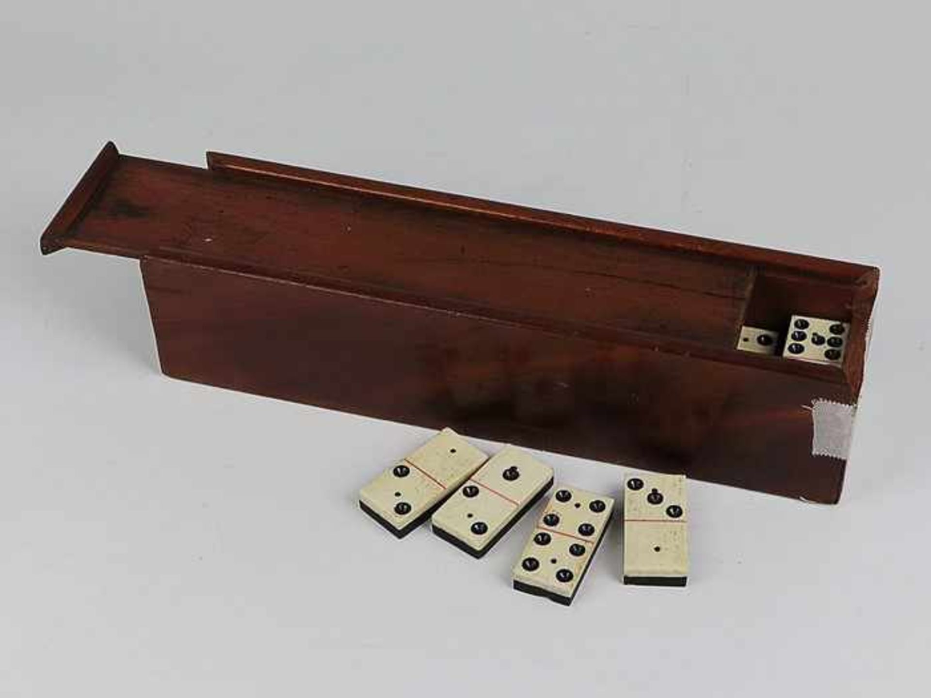Domino-SpielBein, Holz, ebonisiert, im Holzkasten, bei diesem 1 Schmalseite besch. u. Riss im