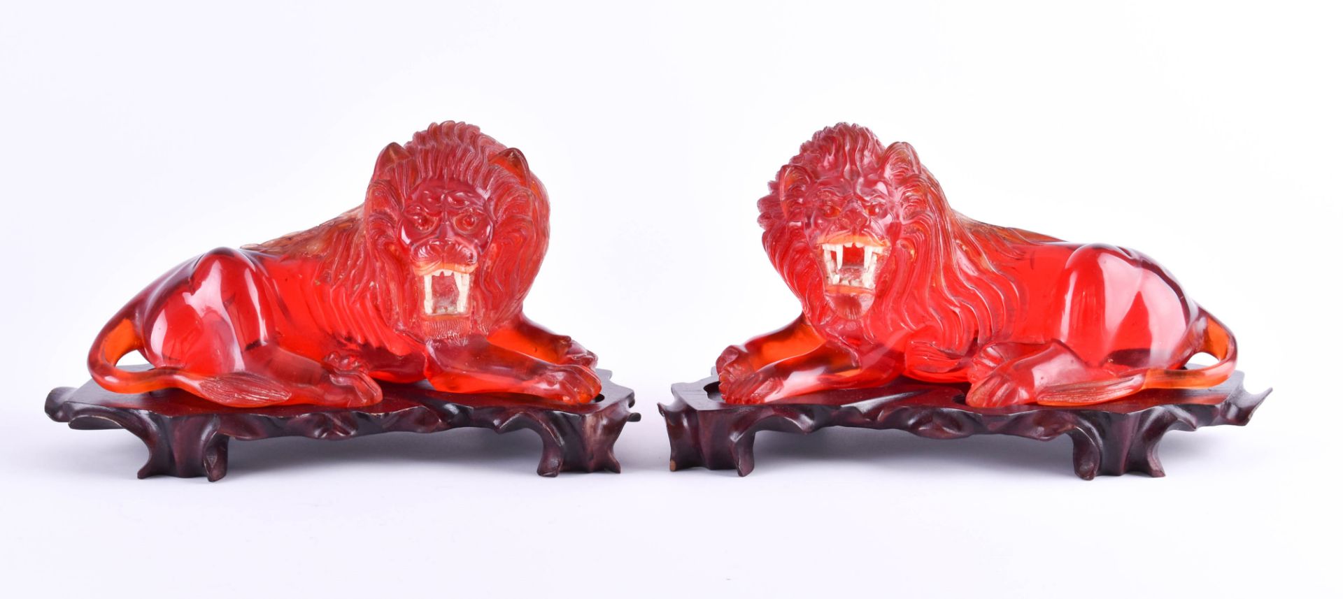 Pair of lions China 20th centuryAmber, copal ???, lying on a wooden base, very decorative, overall