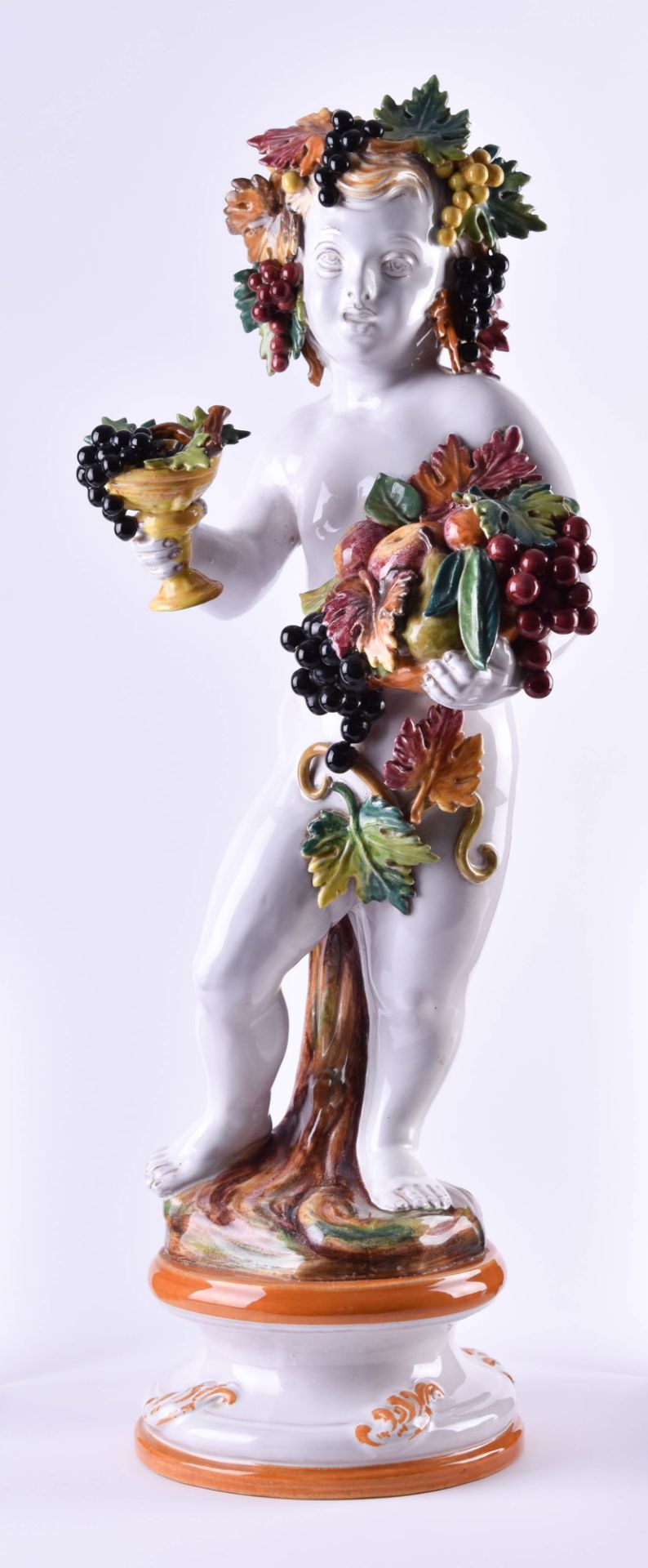 GroßeMajolika Figur"Großes bacchantisches Kind", farbig gefasst mit Früchten und Laub, H: 73 cmLarge