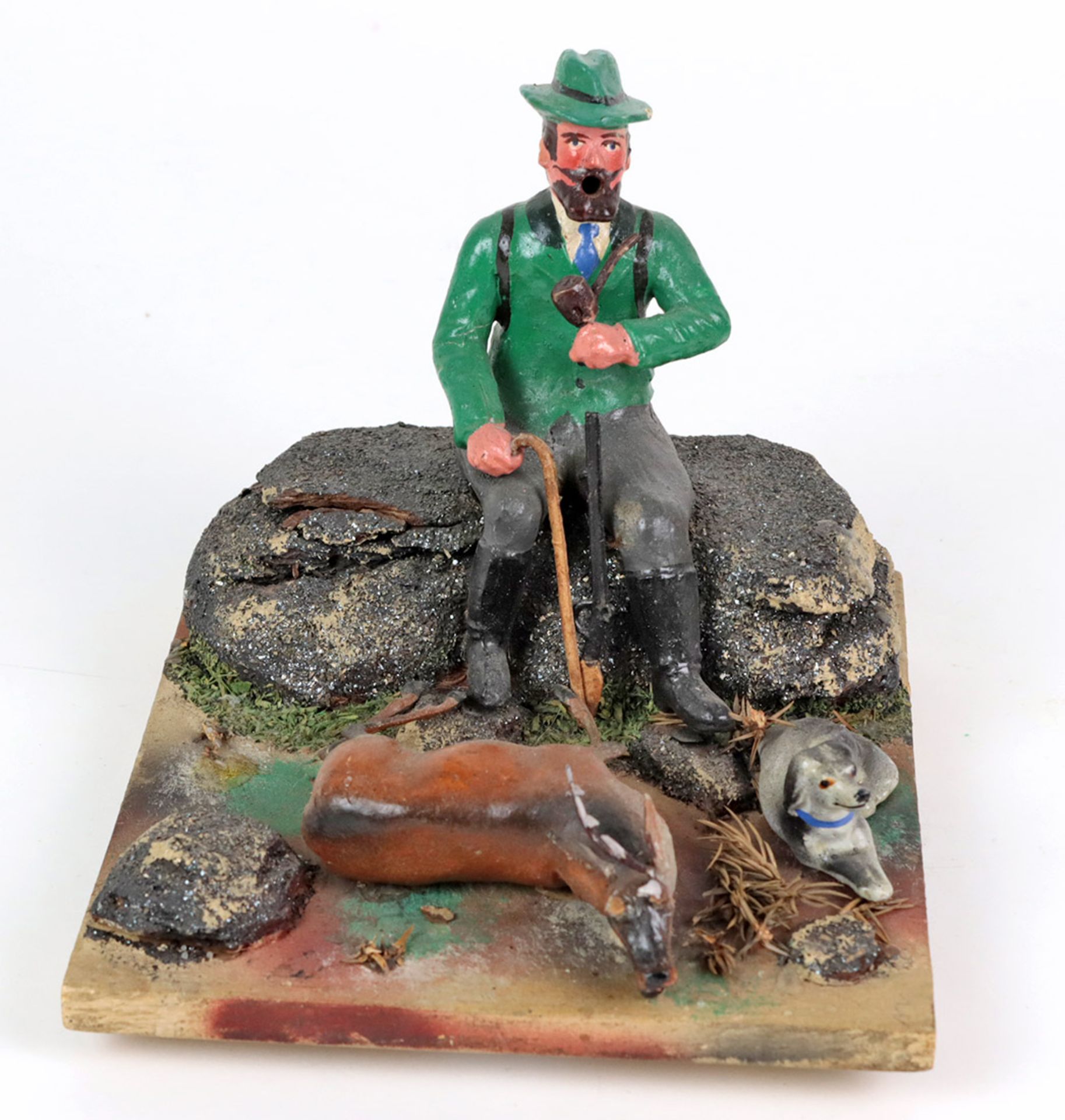 Räuchermann als JägerMasse farbig gefasst, auf Fels sitzender Jäger, mit Jagdhund u. erlegtem Hirsch