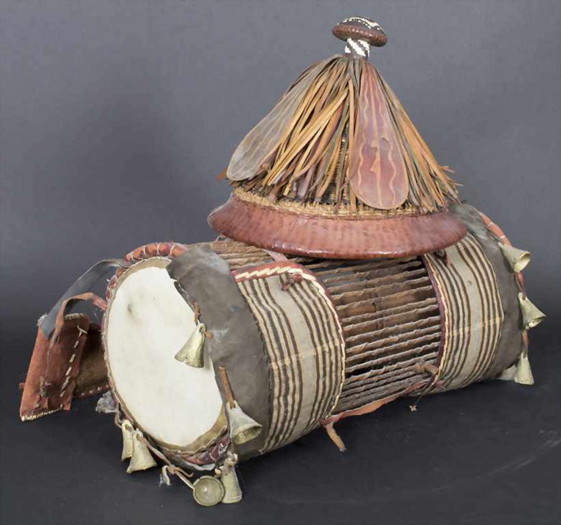 Trommel und Hut, WestafrikaMaterial: Leder, Planzenfaser, Stoff, Holz, Messing-Glocken,Maße: Trommel