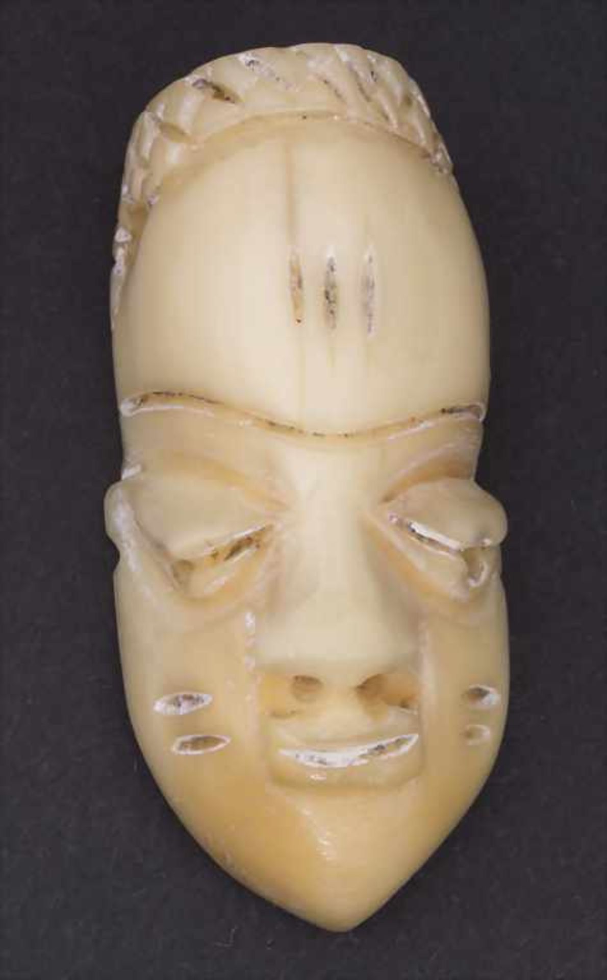 Amulettmaske (Passportmaske), Pende, D.R.KongoMaterial: wohl Nilpferdzahn,Höhe: 4,5 cm,Zustand: gut-