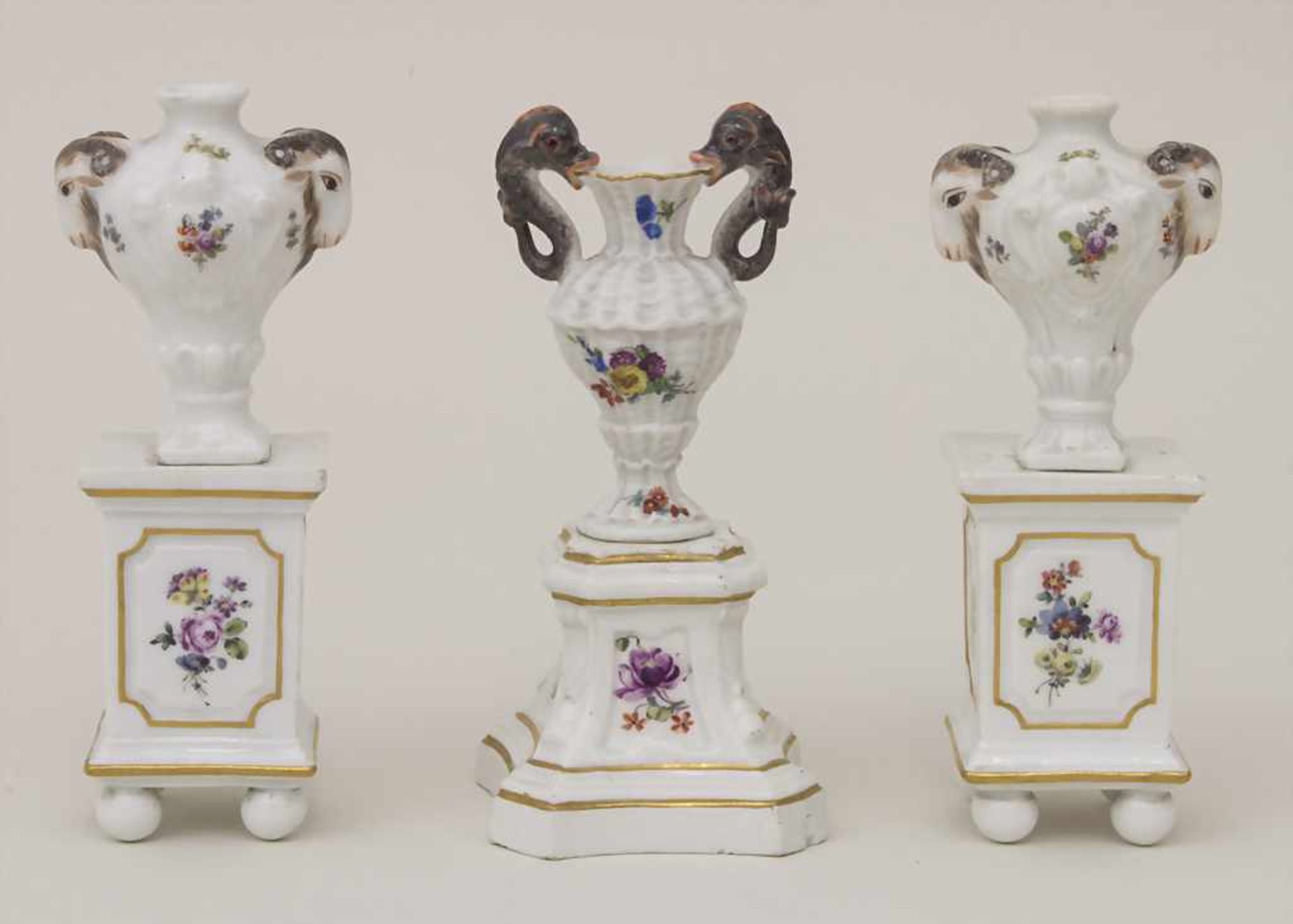 3 Miniatur Vasen mit Widderköpfen und Delfinen auf Postamenten / 3 miniature vases with ram heads