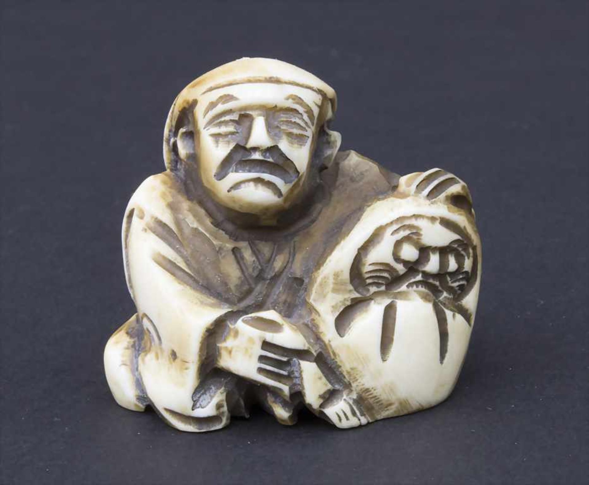 Netsuke 'Man mit Kind im Sack' / A netsuke 'man with child in a bag', Japan, um 1900