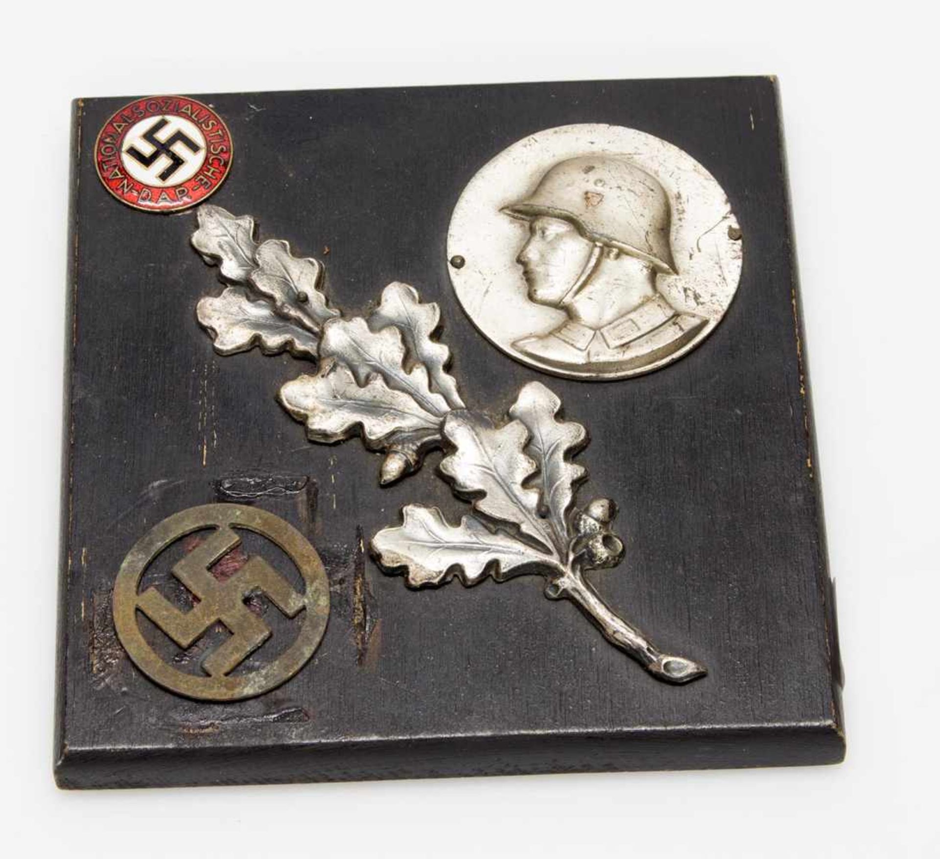 ErinnerungsplaketteII. WK, diverse Symbole u. Parteiabzeichen d. NSDAP auf Holzplatte aufgebracht