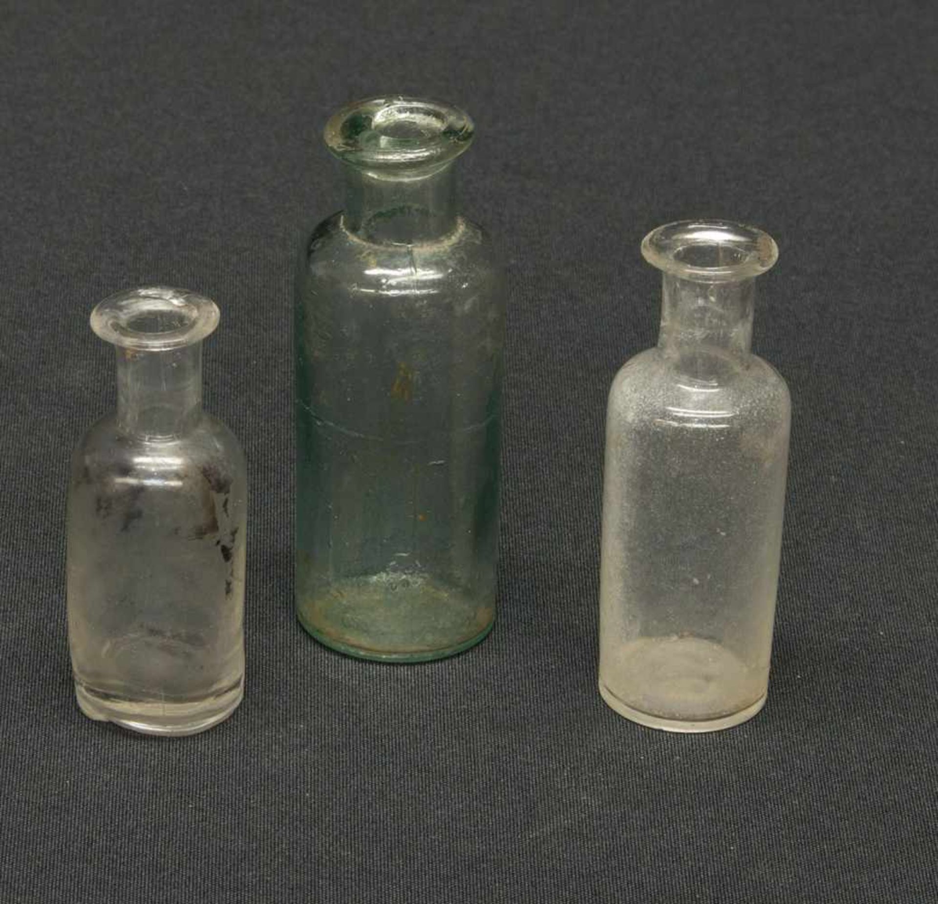 3 Apothekerfläschchenum 1900, farblose u. grünliche Glasmasse, H. 6 - 8 cm