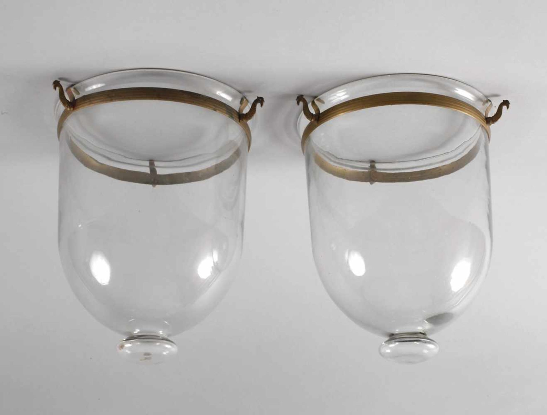 Zwei Lampenschirme2. Hälfte 19. Jh., Klarglasglocken mit ringförmigen Messingmontierungen, leichte
