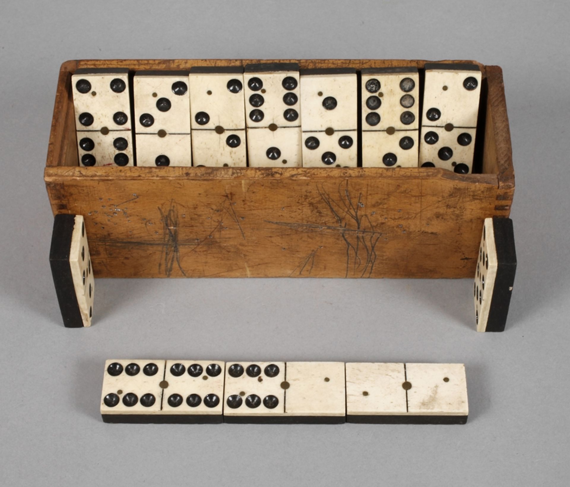 Dominospiel19. Jh., 26 massive Spielsteine aus Bein und Ebenholz, mittels Messingnieten montiert,