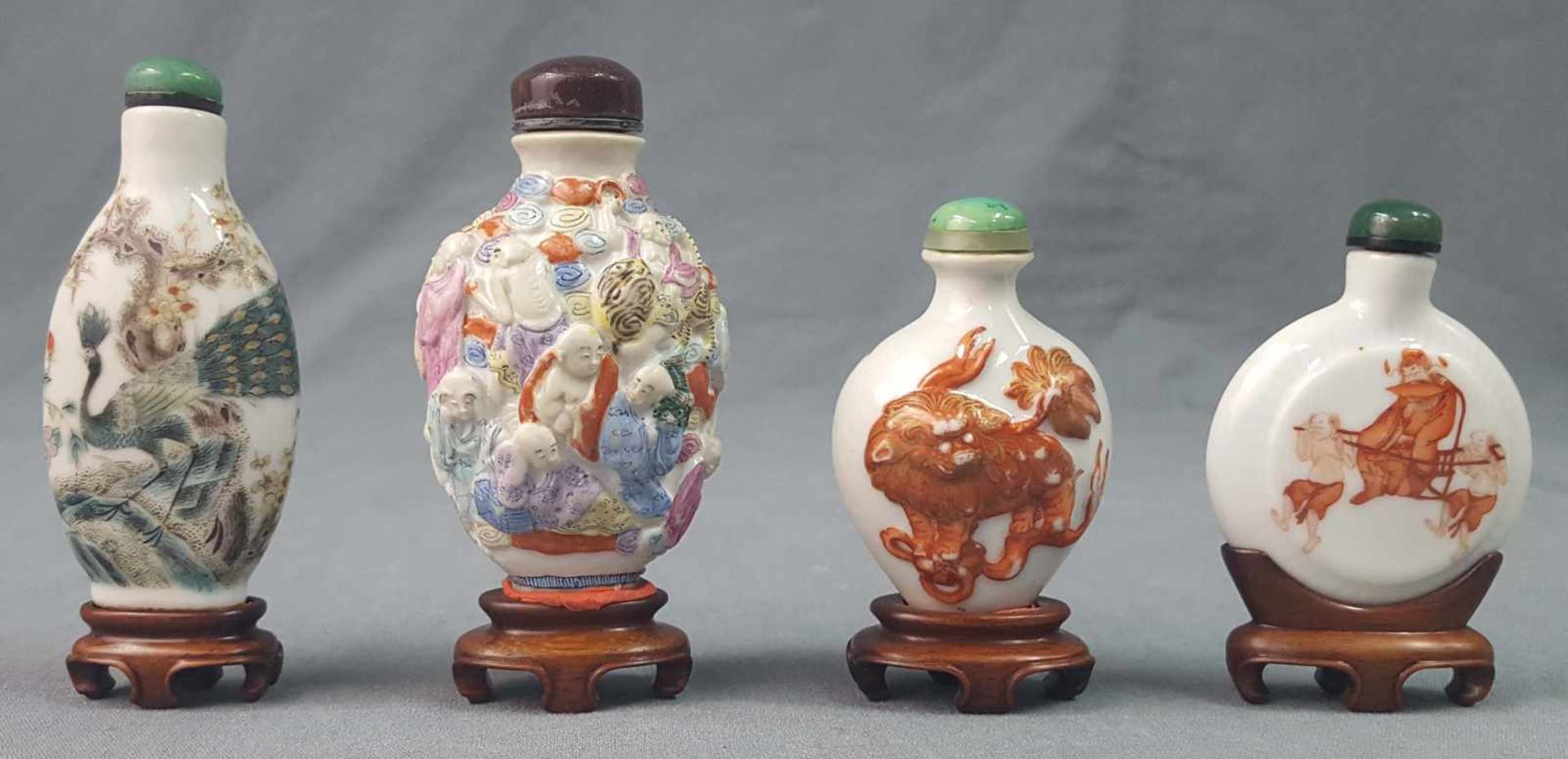 4 snuff bottles. China / Japan, old. Each with a wooden base.