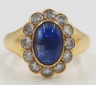 Yellow gold 750 ring with a Sapphire cabochon framed by 12 diamonds.
